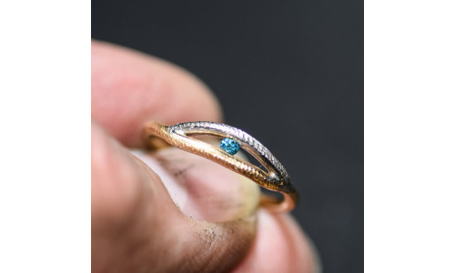 Ring af filet tråd i 2 farvet 14 karat guld isat blå brillant i spændfatning   (11/25)